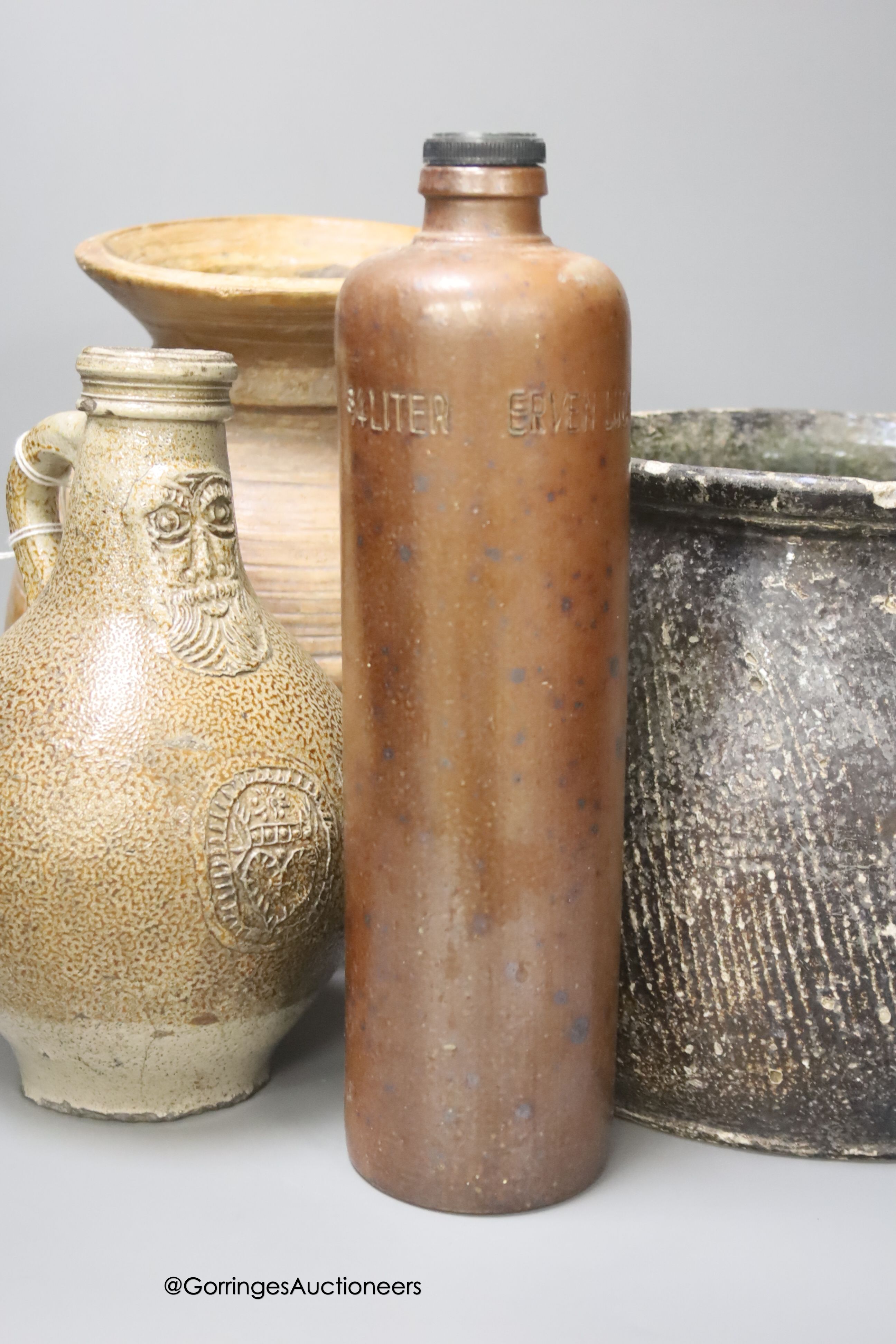 A 17th century continental Tiger ware Bellarmine, 23cm, together with a two handled earthenware bowl, a turned wood bowl and a cylindrical stoneware flask